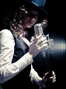 mikrofon ile şapkalı güzel şarkıcı