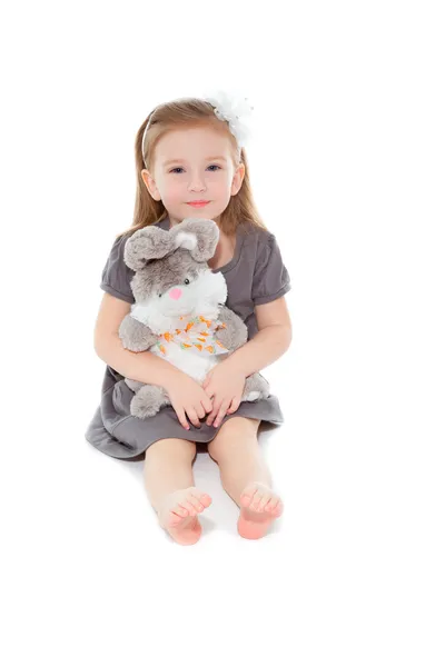 Little girl with toy sitting on the floor — Stock Photo, Image