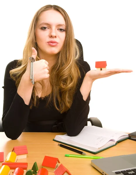 Geschäftsfrau mit Schlüssel und Spielzeughaus im Büro — Stockfoto