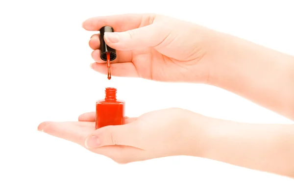 Kvinnans händer som håller en flaska rött nagellack — Stockfoto