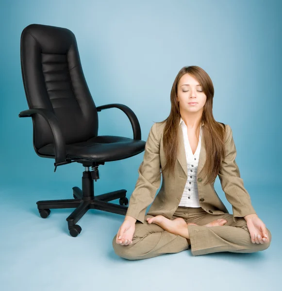 Young woman in costume sitting in lotus pose on the floor — Stock Photo, Image