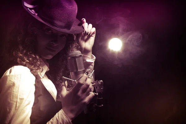 Beautiful singer in hat with microphone — Stock Photo, Image