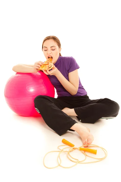 Mulher com uma fatia de pizza, bola de ginástica rosa e corda de salto — Fotografia de Stock