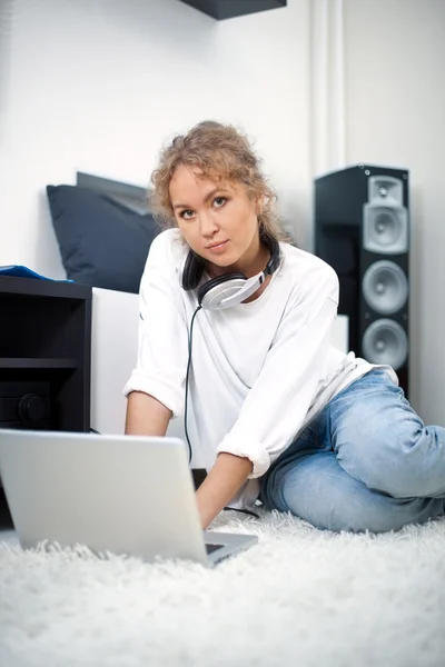 Bella donna con computer portatile seduto sul pavimento — Foto Stock