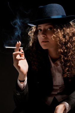 güzel bir kadın ayakta ve siyah üzerine sigara