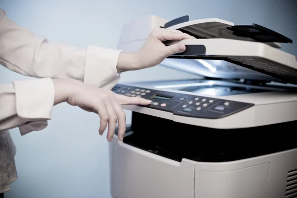 Woman's hand with working copier — Stock Photo, Image