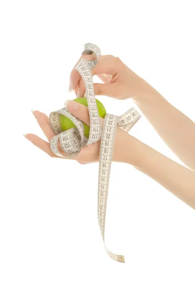 Woman's hands holding green apple with measuring tape isolated — Stock Photo, Image