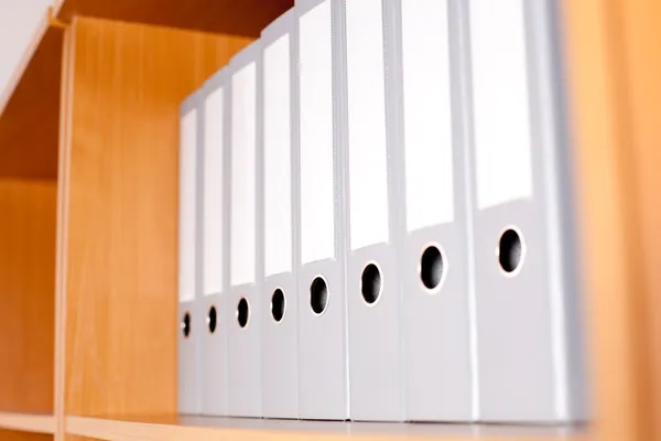 Shelf with gray folders at office — Stock Photo, Image