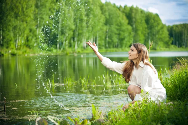 Ung kvinna nära vatten — Stockfoto