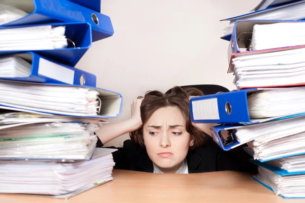 Gefrustreerd zakenvrouw met stack van mappen — Stockfoto