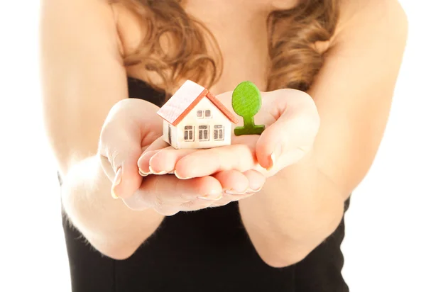 Woman's hands holding a house and a thee — Stock Photo, Image