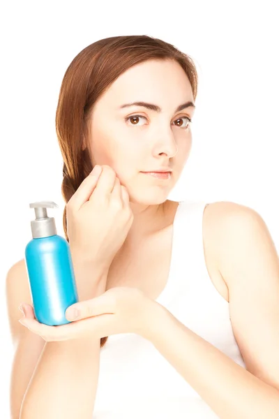 Beautiful woman with a bottle of a cream — Stock Photo, Image