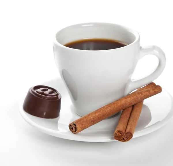 Hot cup of coffee with cinnamon sticks and candy — Stock Photo, Image