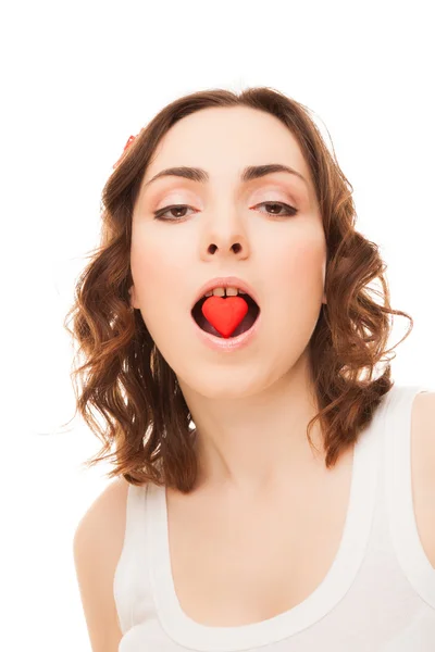 Jeune femme avec un cookie en forme de coeur dans la bouche — Photo