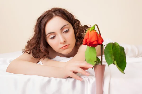 Foto de una hermosa mujer triste con una rosa marchita — Foto de Stock