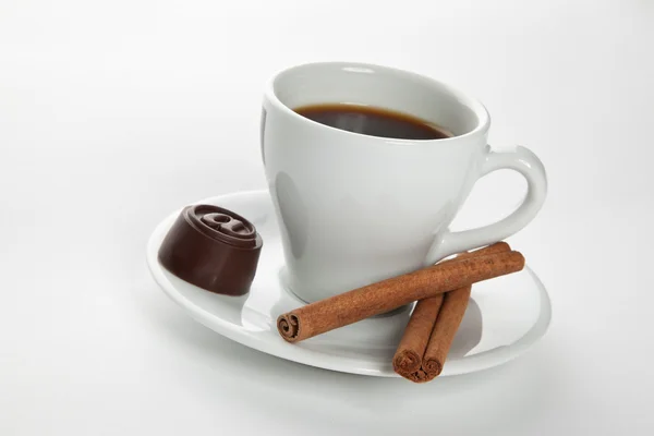 Hot cup of coffee with cinnamon sticks and candy — Stock Photo, Image