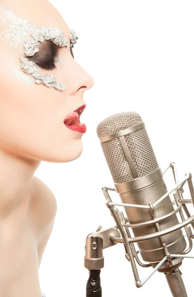 Женщина в маске из фольги с студийным микрофоном — стоковое фото