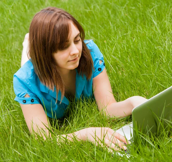 Mulher com laptop deitado na grama — Fotografia de Stock