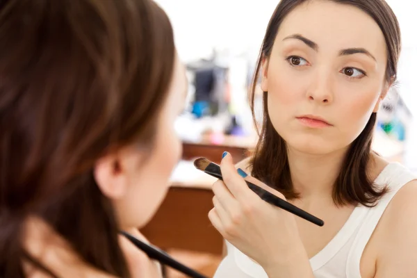 A picture of a mirror reflection of a beautiful girl putting on — Stock Photo, Image