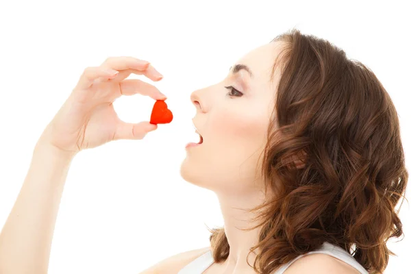 Mujer joven comiendo galletas en forma de corazón aislado — Foto de Stock