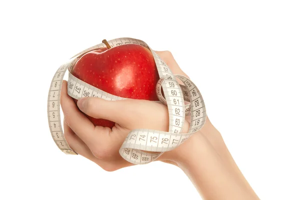 Manos de mujer sosteniendo manzana roja con cinta métrica — Foto de Stock