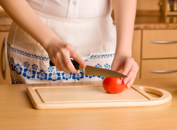 Manos de mujer con cuchillo cortando tomate — Foto de Stock