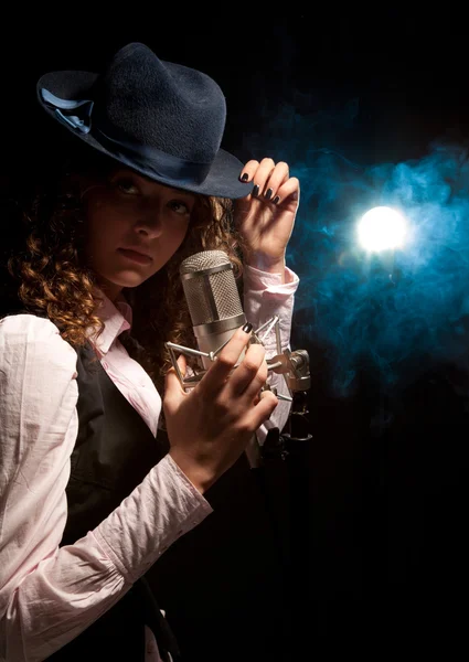 Beautiful singer in hat with microphone — Stock Photo, Image