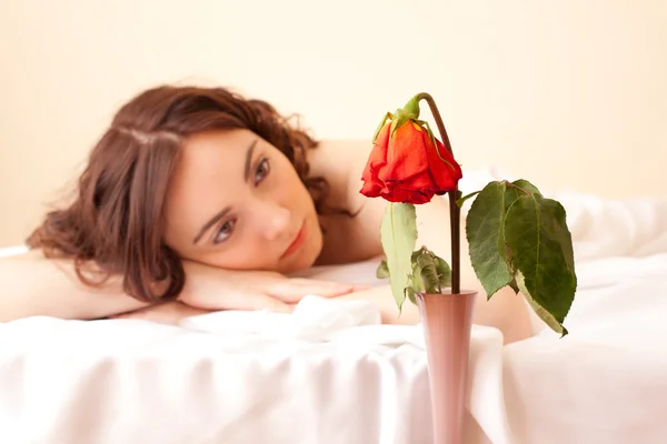 Frau im Bett mit Blick auf die Rose (Schwerpunkt Rose)) — Stockfoto