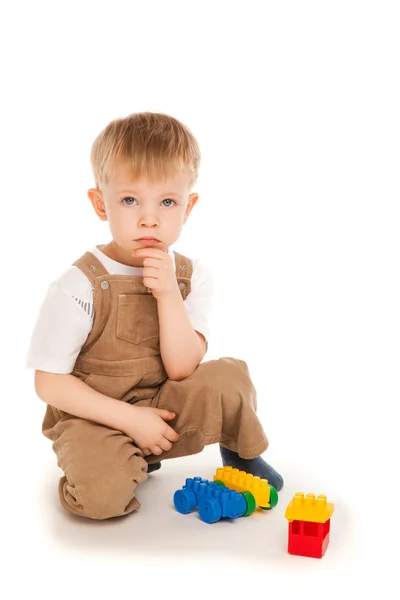 Enfant réfléchi jouant avec des jouets isolés — Photo