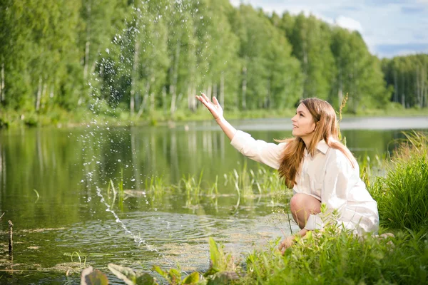 Mladá žena u vody — Stock fotografie