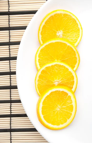 Corte de naranja en el plato blanco — Foto de Stock