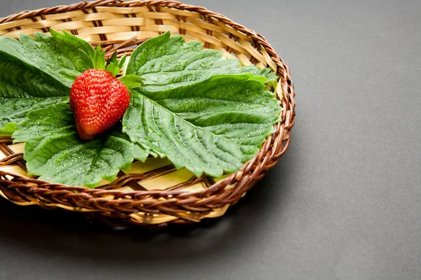 Strawberry with leaves on the plate — Stock Photo, Image