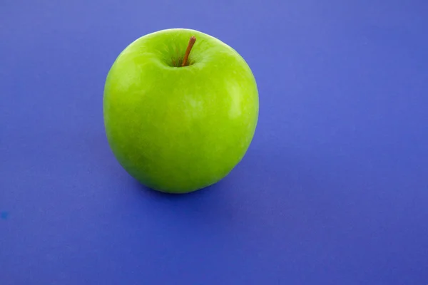 Picture of green apple on blue background — Stock Photo, Image