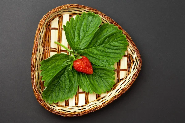 Strawberry with leaves on the plate — Stock Photo, Image