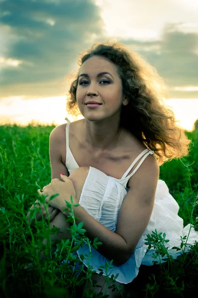 Imagen de una hermosa mujer sentada sobre hierba — Foto de Stock