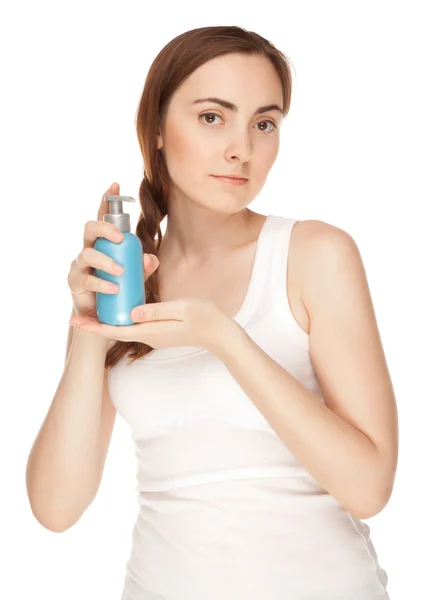 Beautiful woman with a bottle of a cream — Stock Photo, Image