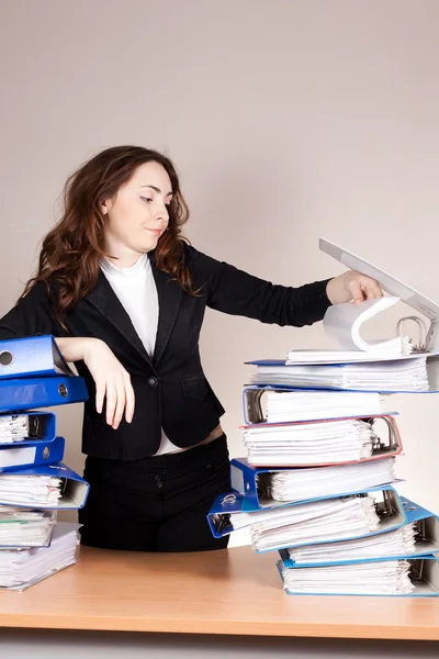 Mulher de negócios frustrada com pilha de pastas no escritório — Fotografia de Stock