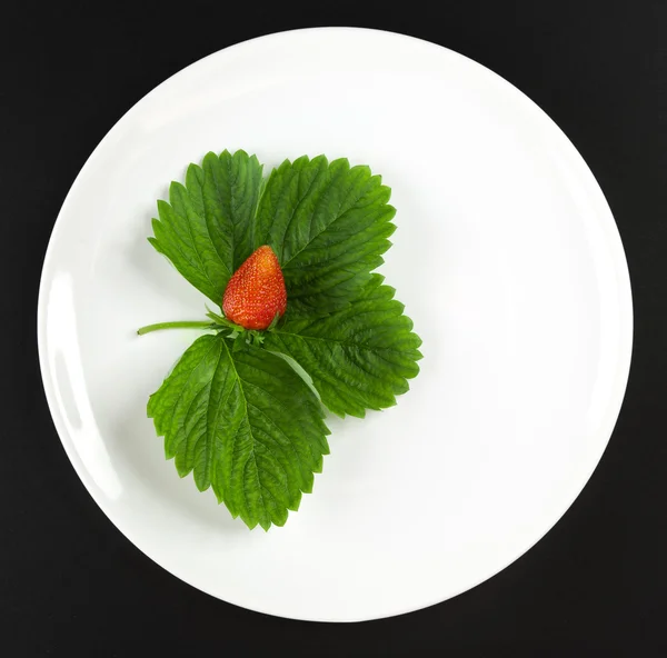 Fresa con hojas en el plato blanco —  Fotos de Stock