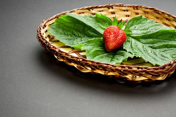 Strawberry with leaves on the plate — Stock Photo, Image