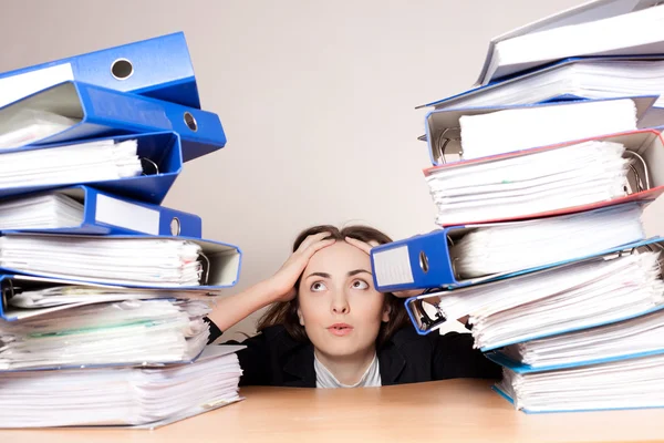 Frustrierte Geschäftsfrau mit Stapel Ordnern im Büro — Stockfoto