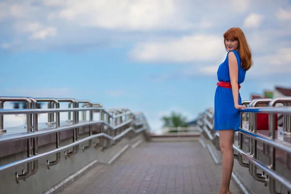 Schöne Frau in blauem Kleid und rotem Gürtel — Stockfoto