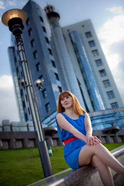 Hermosa mujer en vestido azul contra la construcción —  Fotos de Stock