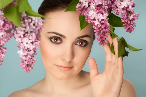 Portret van mooie vrouw met make-up en tak van lila — Stockfoto