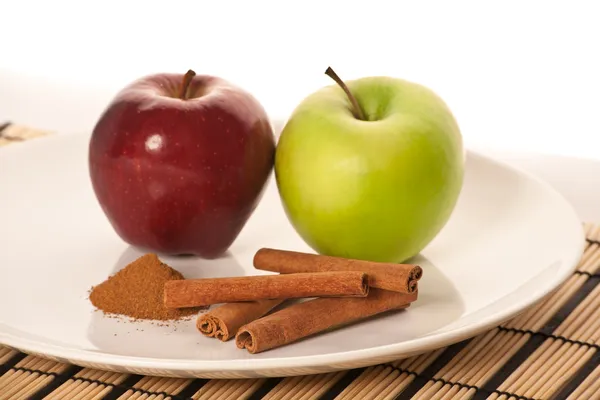 Imagen de manzanas y especias en el plato blanco (enfoque en cinnam —  Fotos de Stock