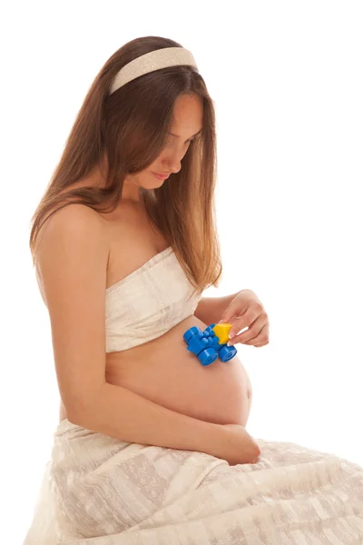 妊娠中の女性と彼女の腹でおもちゃの車 — ストック写真