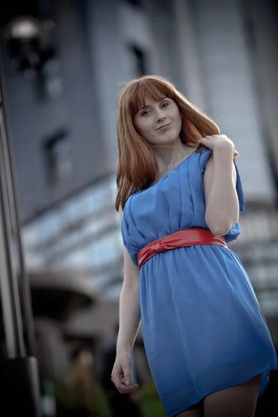Schöne Frau in blauem Kleid und rotem Gürtel — Stockfoto