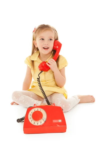 Bambina con vecchio telefono rosso seduto sul pavimento — Foto Stock