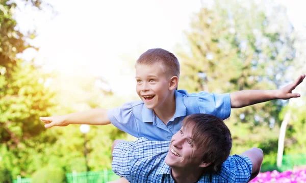 Счастливые отец и сын играют в парке — стоковое фото