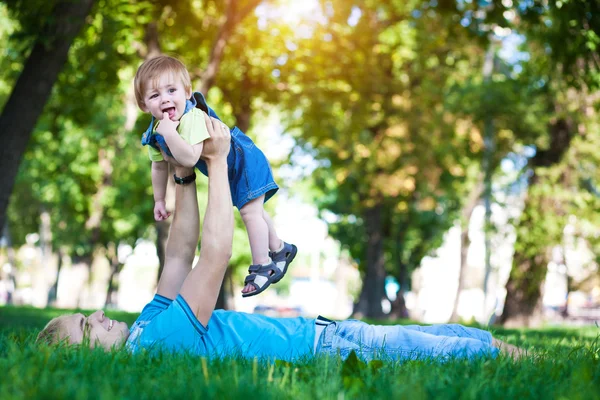 Glad pappa med baby i en greenl sommar park — Stockfoto