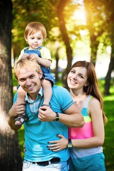 Lycklig familj promenader i parken gröna sommaren — Stockfoto